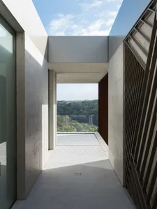 A minimalist patio with concrete and glass elements.