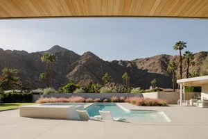 Modern residential outdoor space featuring a swimming pool, mountain view, and landscaping.