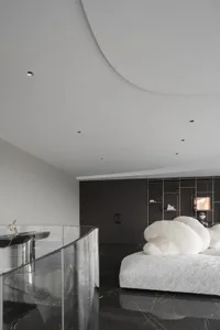 A minimalist bedroom featuring marble flooring and metallic accents
