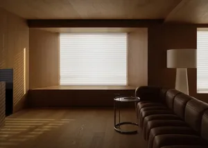 A modern living room with wooden walls, a large window with blinds, a brown leather sofa, and a small round table.