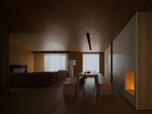 Minimalist living room with wooden furniture and floor-to-ceiling windows.
