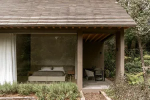 A minimalist residential space featuring wood, glass, and cement materials.