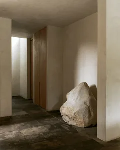 A minimalist living room with concrete flooring and modern design elements.