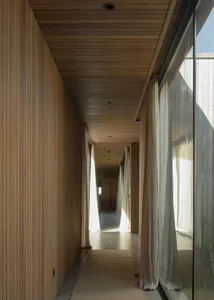 A minimalist interior design featuring wooden paneling walls and white curtains.
