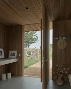 An entrance with wooden panels and a view of the outdoors through an open door.