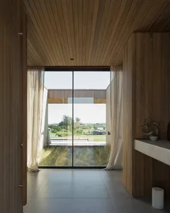 Modern interior design featuring wooden walls, glass windows, and a view of the outdoors.