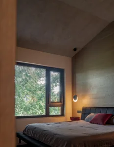 Minimalist-style bedroom featuring wooden walls and floors, with a large window overlooking greenery and a simple bed with cu
