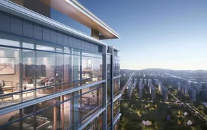Modern apartment building with large glass windows and balconies overlooking a cityscape.