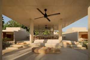 A modern living room with concrete furniture and minimalist decor.