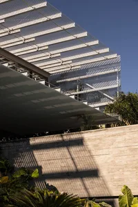 Modern exterior with metal pergola and concrete wall.