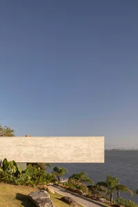 Modern house with a concrete exterior overlooking the ocean.