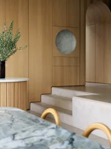 Modern kitchen featuring minimalist design with marble countertops and wooden elements.