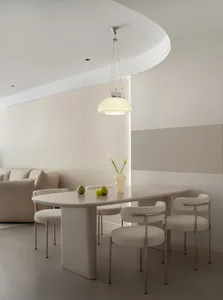 A modern dining room with white furniture and minimalist decor.