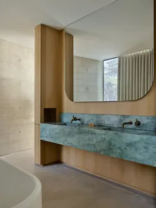 Modern minimalist bathroom with blue marble countertop, wooden cabinetry, and a large mirror.