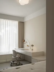 A minimalist bedroom with a white desk, chair, and bed in a modern, serene space.