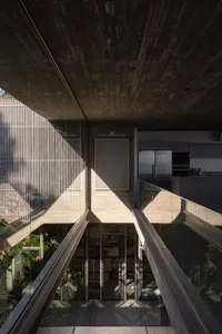 A futuristic industrial-style residential kitchen designed with concrete and glass materials, featuring a sleek, modern aesth
