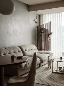 Modern living room with neutral fabrics, wood accents, and a cat climbing structure