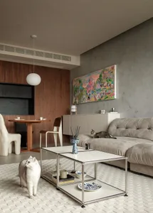 A modern living room featuring concrete, wood, metal, and fabric materials.