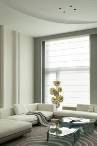 A modern living room with a taupe-colored fabric sofa and coffee table, featuring a minimalist design with a large window and