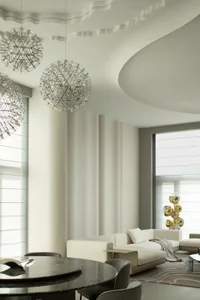 A modern minimalist living room with white sofas, floor-to-ceiling windows, and metallic pendant lights hanging from the ceil
