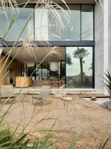 Modern residential exterior with concrete finish and glass windows.