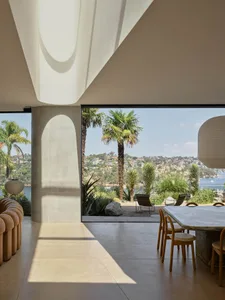 Modern residential interior featuring concrete flooring and wooden furniture.