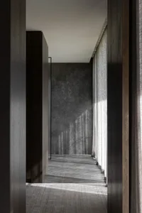 Modern residential interior with gray marble walls and glass partitions.