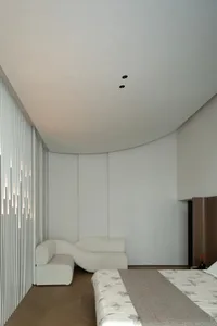 Neutral-toned minimalist bedroom with sleek lines and modern furniture.