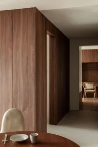 A modern residential interior with wooden cabinetry and white tiled floor.