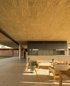 Concrete living room with minimalist furniture and large windows.