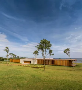 Modern residential extension with wooden exterior against a blue sky.