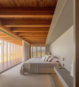 Industrial-style bedroom with light-colored wood elements and large windows.
