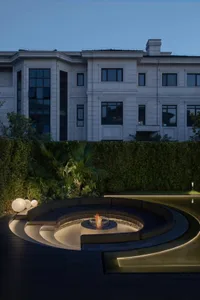 A modern residential patio featuring concrete and glass elements.