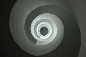 A modern staircase made of white concrete with circular steps.