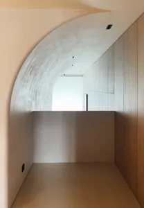 A minimalist interior space with concrete walls and flooring.