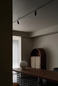 A modern dining room with a wooden table and decorative vase.