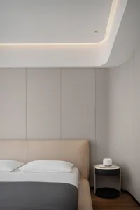 A modern bedroom with neutral-toned materials and a minimalist design.