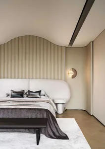 Minimalist bedroom featuring a bed with a cream and taupe striped velvet headboard and matching cover, complemented by a grey