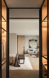 Interior design photo of a modern bedroom featuring wooden furniture and fabric-covered seating.