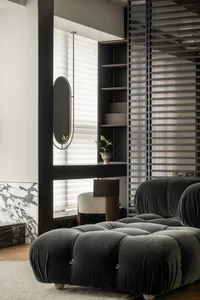 Modern living room featuring plush, tufted black velvet furniture, a round table, and minimalist decor.