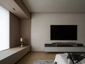 Modern minimalist living room with wood flooring, leather furniture, and metal accents.