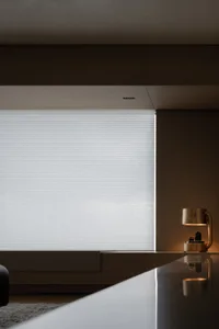 A modern interior space featuring minimalist window blinds and sleek, contemporary design elements.