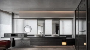 Modern bathroom interior with black concrete floor and walls, featuring a double vanity with marble countertops and sinks.