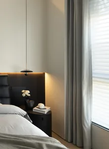 Modern bedroom with textured fabric and leather accents.