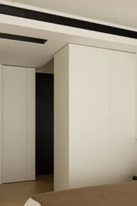 Sleek, white minimalist bedroom with neutral tones and modern design.