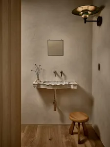 Minimalist bathroom with concrete sink and wooden stool