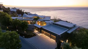 A modern residential exterior with a metal roof at sunset.