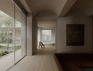 A modern minimalist living room with concrete walls and floors, featuring a large window, a minimalist sofa, and a painting o