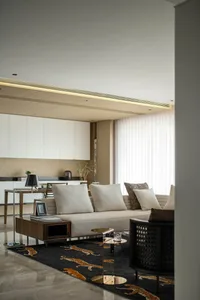 Modern living room with fabric sofa, wooden furniture, and glass coffee table.