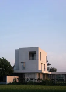 A modern, minimalist house featuring precast concrete walls and a glass facade.